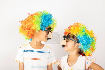 Photo for April Fools Day. Two brothers funny kid boy and little girl clown wears curly wig colorful big nos and glasses and has mustache isolated on white background, Happy children festive decor - Royalty Free Image