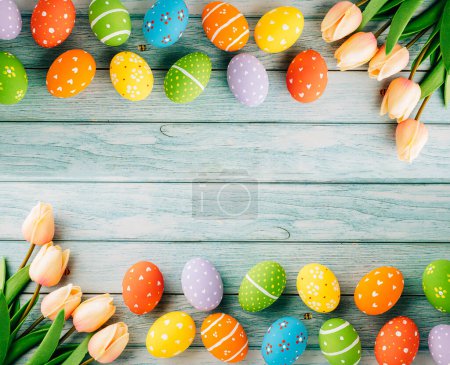 Téléchargez les photos : Happy Easter Day Concept. Flat lay holiday banner background web design white colorful easter eggs painted with tulips flowers on blue wood background with empty copy space, overhead, template - en image libre de droit