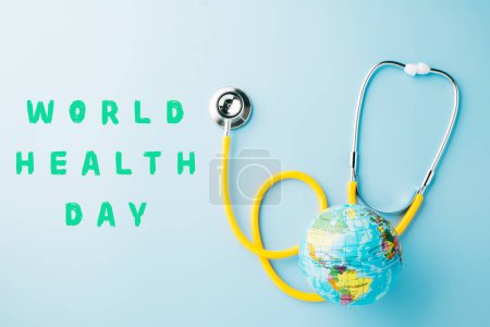Photo for World Health Day. Yellow doctor stethoscope and world globe isolated on pastel blue background with copy space for text, Save world day, Green Earth Environment, Healthcare and medical concept - Royalty Free Image