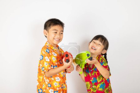 Photo for Happy Songkran Day, Asian kid girl and boy holding plastic water gun, Thai child funny smiling hold toy water pistol, isolated on white background, Thailand Songkran festival national culture concept - Royalty Free Image
