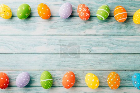 Téléchargez les photos : Happy Easter Day Concept. Top view holiday banner background web design white colorful easter eggs painted on blue wood background with empty copy space, celebration greeting card, overhead, template - en image libre de droit