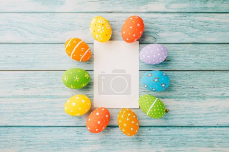 Photo for Easter Day Concept. Flat lay holiday banner background web design white colorful easter eggs composition with paper rectangle blank on blue wood background with empty copy space, celebration greeting - Royalty Free Image