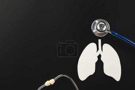 Photo for World TB Day. Lungs paper cutting symbol and medical stethoscope on black background, copy space, lung cancer awareness, concept of world tuberculosis day, banner background, respiratory diseases - Royalty Free Image