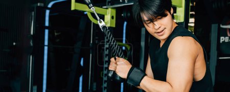 Foto de Atleta usando una máquina de cable para hacer tiradas de tríceps, trabajando en el entrenamiento de fuerza para un cuerpo en forma y saludable. Ejercicio de fuerza superior - Imagen libre de derechos