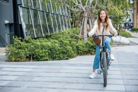 Photo for Portrait of smiling female lifestyle using bike in summer travel means of transportation, Happy Asian beautiful young woman riding bicycle on street outdoor near building city, ECO friendly concept - Royalty Free Image