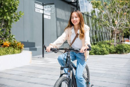Photo for Happy Asian young woman riding bicycle on street outdoor near building city, Portrait of smiling female lifestyle use mountain bike in summer travel means of transportation, ECO friendly, Urban biking - Royalty Free Image