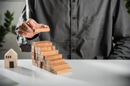 Photo for Business hand arranging put wooden block stacking step stair growth success process, financial risk management and strategic plan and business challenge planning concept, prevent collapse or crash - Royalty Free Image