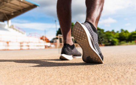 Photo for Asian young athlete sport runner black man wear feet active ready to running training at the outdoor on the treadmill line road for a step forward, healthy exercise workout, closeup back shoe - Royalty Free Image