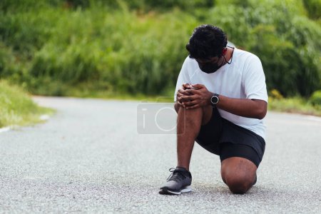 Photo for Close up Asian young sport runner black man wear watch sitting hands joint hold knee pain during the run while running at the outdoor street health park, healthy exercise injury from workout concept - Royalty Free Image