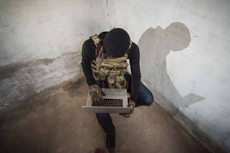 Téléchargez les photos : Homme terroriste cyberpirate piratage Internet pour accéder à voler des informations par ordinateur portable, concept criminel voleur - en image libre de droit