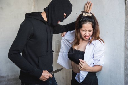 Téléchargez les photos : Voleur homme utilisant couteau force jeune femme enlever sa chemise pour le viol sexuel, concept de voleur criminel - en image libre de droit