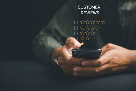 Photo for Unhappy client concept. Giving a 1-star satisfaction rating on social media using a smartphone. Negative feedback impacting business reputation and customer experience. - Royalty Free Image
