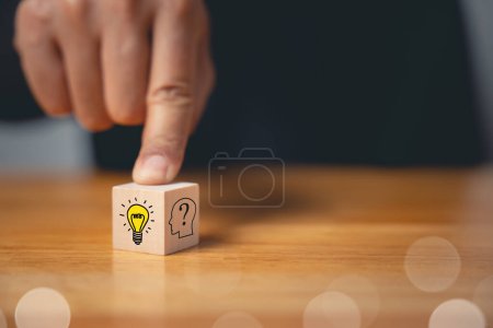 Photo for Expert consulting and creative solution concept. Hand holding wooden block with glowing light bulb icon. Development of new ideas and innovation strategy. Business success through creative imagination - Royalty Free Image