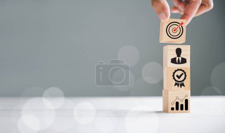 Téléchargez les photos : Businessmans main tenant un cube de bloc en bois avec une icône, représentant le développement de la stratégie de l'entreprise. Concept de réussite et objectifs commerciaux. - en image libre de droit
