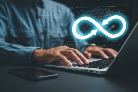 DevOps engineer in agile environment. infinity icon on computer, coder typing. Integration of software development IT operations. concept of continuous integration. technology infinity data-stock-photo