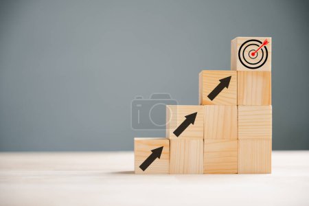 Photo for Business and target concept depicted by a hand positioning a print screen dart and wooden cube on upward arrows. Symbolizing success, development, and financial growth. White background. - Royalty Free Image