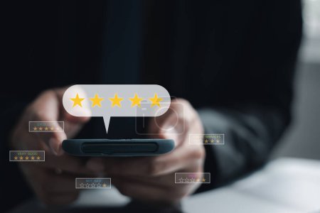Hand pressing gold star rating feedback icon on smartphone. Excellent rank for giving best score point to customer satisfaction survey and service review