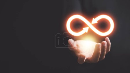 Photo for Businessman with circular infinity symbol on palm, symbolizing circular economy and infinite possibilities. Strategy of sustainable investment, banking, and financial growth. technology infinity data - Royalty Free Image