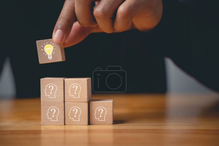 Photo for New initiative and strategy consultation. Wooden block with glowing light bulb on hand icon against. Innovative ideas and creative solutions for business success. Expertise and vision for digital - Royalty Free Image