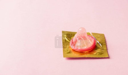 Foto de Día Mundial de la Salud Sexual o el Sida, Vista superior plano laico condón en paquete de envoltura es rasgón abierto, estudio de disparo aislado en un fondo rosa, Sexo seguro y el concepto de salud reproductiva - Imagen libre de derechos