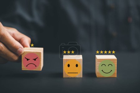Photo for Customer Experience dissatisfied concept. Unhappy customer hand with a sadness emotion face on a wood block. Bad service quality, low rating, and negative feedback affecting business reputation. - Royalty Free Image