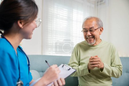 Photo for Elderly man takes doctor at home telling about health complaints, Asian young nurse writing prescription clipboard while talking during home visit sick senior old man, Healthcare and medical concept - Royalty Free Image