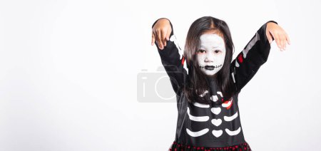 Téléchargez les photos : Halloween Kid. Child woman horror face painting make up for ghost scary, Portrait of Asian little kid girl wearing witch costume studio shot isolated white background, Happy halloween day concept - en image libre de droit