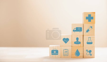 Foto de Una pirámide de cubos de madera forma una metáfora visual para la atención médica y los seguros. Coronando el icono del seguro médico sobre fondo blanco, permitiendo el espacio de copia para la mensajería del Seguro de Salud. - Imagen libre de derechos