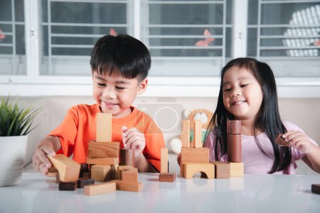 Photo for Children boy and girl playing with constructor wooden block building, Happy little kids play wood block stacking board game at home, activities learning creative, toys for preschool and kindergarten - Royalty Free Image