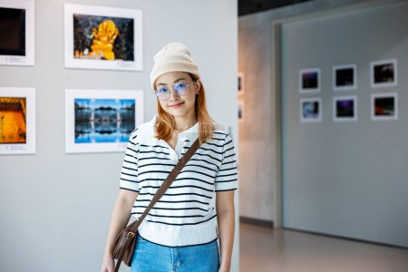 Photo for Visitor woman smiling on art gallery collection in front framed paintings pictures on white wall, lifestyle Asian people watch at photo frame to leaning against at show exhibition artwork gallery - Royalty Free Image