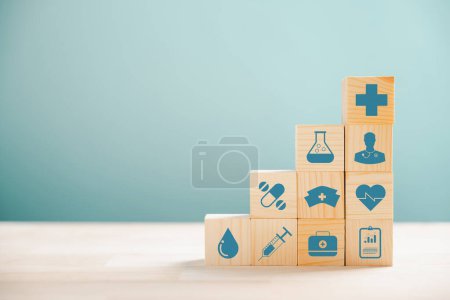 Photo for Wooden cubes in pyramid shape, illustrating the healthcare and insurance concept. Icon of medical insurance atop signifies protection. Blue background with copyspace for Health Insurance theme. - Royalty Free Image