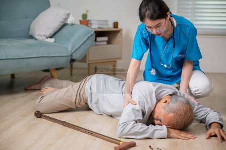 Téléchargez les photos : Homme handicapé âgé patient avec bâton de marche tomber sur le sol et assistant soignant à la maison de soins infirmiers, Asiatique vieillard tomber sur le sol couché et infirmière femme aidant le soutien dans le salon - en image libre de droit