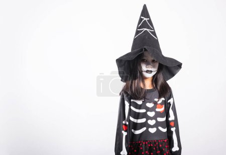 Téléchargez les photos : Halloween Kid. Child woman horror face painting make up for ghost scary, Portrait of Asian little kid girl wearing witch costume studio shot isolated white background, Happy halloween day concept - en image libre de droit