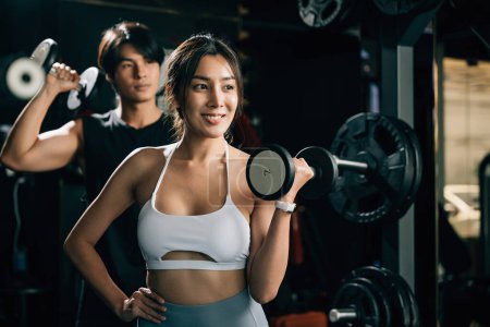 Photo for A muscular man and slim woman, both athletes, work out in a gym with barbells and weights, showcasing their dedication to building strength and fitness. lifestyle fitness concept - Royalty Free Image