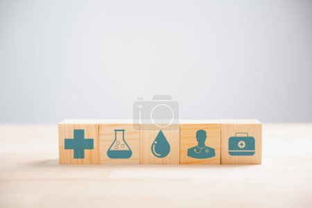 Foto de Pila piramidal de bloques de cubo de madera con un icono médico, que simboliza la salud y la tecnología médica. Contra el telón de fondo blanco, proporcionando espacio de copia para temas de vacunación, salud y seguros. - Imagen libre de derechos