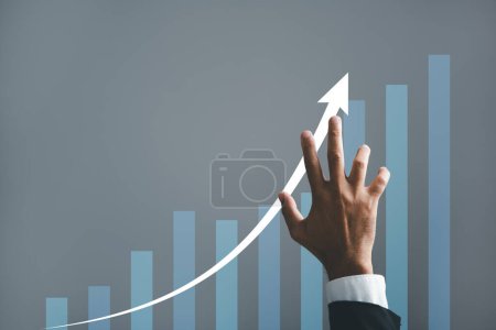 Foto de Una mano de hombre de negocios señala estratégicamente una flecha en un gráfico, simbolizando el plan de crecimiento futuro corporativo. Esta cautivadora imagen ilustra el concepto de desarrollo empresarial, crecimiento y éxito. - Imagen libre de derechos