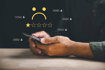 Photo for Customer dissatisfaction concept. Unhappy person hold mobile phone with one star rating. Expressing disappointment, sadness. Bad reviews, bad service low satisfaction. business reputation - Royalty Free Image