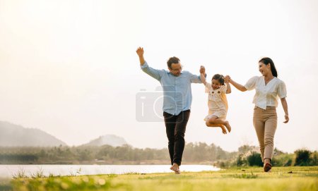 Foto de Familia feliz disfrutando de un día en la naturaleza, corriendo y jugando juntos en un hermoso campo verde, con un cielo soleado y una sensación de diversión y felicidad, Happy Family Day Concept - Imagen libre de derechos