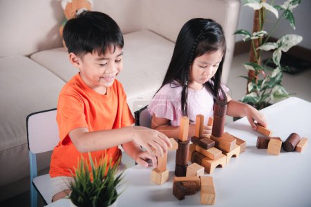 Photo for Happy little kids play wood block stacking board game at home, Children boy and girl playing with constructor wooden block, childhood activities learning creative, toys for preschool and kindergarten - Royalty Free Image