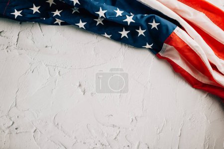 Foto de Para el Día de los Veteranos, una bandera americana vintage se erige, simbolizando el honor, la unidad y el orgullo en los Estados Unidos. Las estrellas y rayas patrióticas son simbólicas. aislado sobre fondo de cemento - Imagen libre de derechos