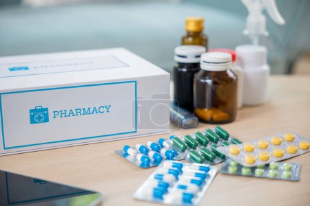 Photo for Home medicine with medicine package box free first aid kit with pills from pharmacy hospital delivery service at home on table in living room, online purchase delivery of medicines to your home - Royalty Free Image