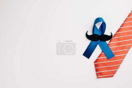 Téléchargez les photos : Symbole d'espoir et de soutien, le ruban bleu avec une moustache et une cravate symbolise la sensibilisation au cancer de la prostate, la promotion des soins de santé pour hommes et la célébration de la Journée mondiale du cancer.. - en image libre de droit