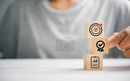 Photo for Hand skillfully arranging wooden blocks to form a structured stack, highlighting the importance of a business strategy and action plan. Targeting business goals and development. - Royalty Free Image