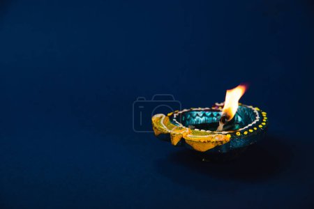 Foto de Celebración de Diwali con vibrantes lámparas diya de arcilla sobre un fondo azul. invitaciones festivas, irradia felicidad y prosperidad. Lámparas brillantes brillantes. Diwali, Holi, lámpara y temática de Dios. - Imagen libre de derechos