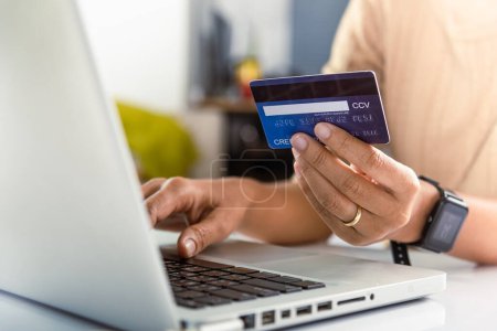 Photo for Female register via credit cards on computer make electronic payment security online, Woman hands holding credit card and using laptop with product purchase at home, Internet online shopping concept - Royalty Free Image