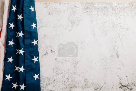 Téléchargez les photos : Célébrez la Journée des anciens combattants avec un drapeau américain vintage, symbolisant l'honneur américain, la fierté et l'unité. Les étoiles et les rayures représentent le gouvernement et la gloire patriotique. isolé sur fond de ciment - en image libre de droit