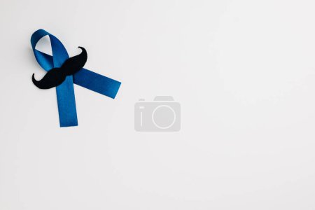 Téléchargez les photos : Vue de dessus d'un ruban bleu avec une moustache, un symbole pour soutenir la santé des hommes, isolé sur blanc. Parfait pour les soins de santé, la Journée internationale des hommes et la Journée des pères. - en image libre de droit