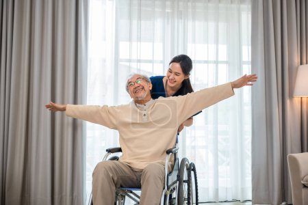 Photo for Asian senior retired old man sitting on wheelchair having fun with young woman nurse, Happy curator person doctor pushing and running elderly patient freedom raising arm, sanatorium - Royalty Free Image