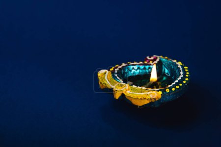Téléchargez les photos : Concept de célébration Diwali et Holi avec des lampes diya en argile vibrante, ces lampes symbolisent la prospérité, la spiritualité du bonheur. Parfait pour les invitations festives. Salutations Diwali et Holi, fond bleu. - en image libre de droit