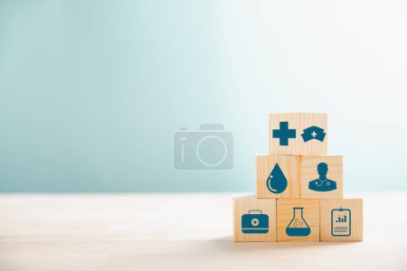 Foto de Cubos de madera apilados como una pirámide, que retrata la salud y el concepto de seguro. Cubierto con un icono de seguro médico contra fondo blanco, lo que permite la comunicación del seguro de salud. - Imagen libre de derechos